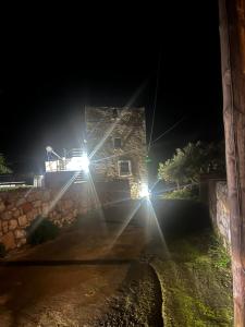 a stone building at night with lights on it at Nigos in Okhiá