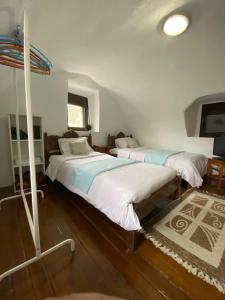 two beds in a room with white walls and wooden floors at Nigos in Okhiá +22 photos