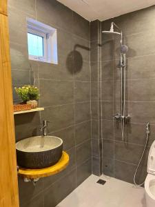 een badkamer met een wastafel en een douche bij Le Petit Homestay 2 in Hue