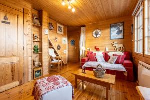 Le Chalet des Ours - Superbe chalet 4 étoiles في ليز أنغلز: غرفة معيشة مع أريكة حمراء وطاولة