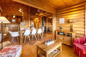 una baita di tronchi con soggiorno dotato di tavolo e sedie di Le Chalet des Ours - Superbe chalet 4 étoiles a Les Angles