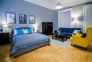 um quarto com uma cama azul e uma cadeira amarela em R171 Elitehost Ráday Apartment em Budapeste
