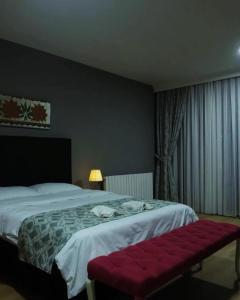 um quarto de hotel com uma cama e um banco vermelho em BY KARAM OTELCİLİK em Istambul