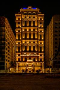 ein hohes Gebäude mit Lichtern in der Nacht in der Unterkunft Paradise Nice Hotel Jeddah in Dschidda