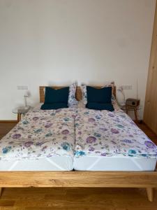 Una cama grande con almohadas azules encima. en Übernachtung beim Bio-Metzger Zimmer "Karl", en Mössingen