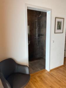 a black chair in a bathroom with a shower at Übernachtung beim Bio-Metzger Zimmer "Karl" in Mössingen