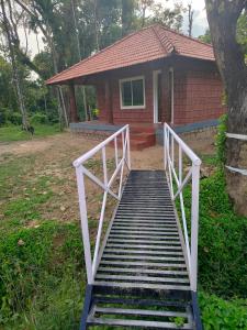 una scala che conduce a una casa con una casa di Nature Spot Cottages a Kurchi