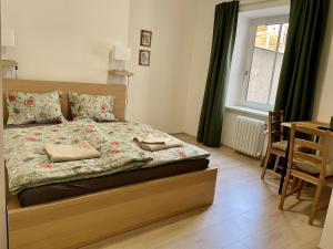 a bedroom with a bed and a table and a window at Apartmán Josefská in Brno