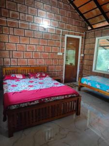 una camera con letto in legno su un muro di mattoni di Nature Spot Cottages a Kurchi