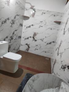 La salle de bains est pourvue de toilettes blanches et d'un lavabo. dans l'établissement Nature Spot Cottages, à Kurchi