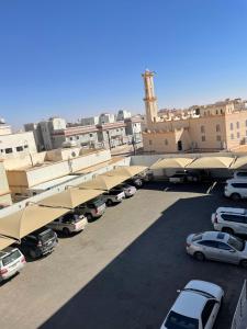a parking lot with cars parked in front of buildings at فندق نوفا بارك in Sharurah
