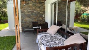 a porch with a bed and chairs on a patio at Studio en Chihuahua in Punta del Este