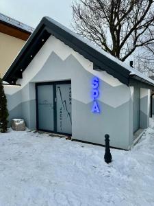 a building with a sign on it in the snow at Richmount Apartamenty Karpacz in Karpacz