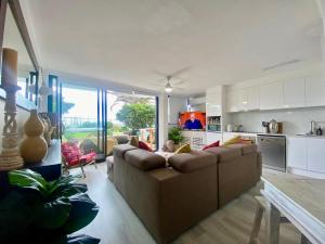 uma ampla sala de estar com um sofá e uma cozinha em Oceanfront Family Apartment Pool & BBQ em Gold Coast