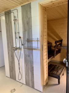 une cabine de douche dans une pièce avec un banc dans l'établissement Kaupunkikoti, à Kemi