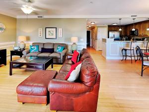 Il comprend un salon avec un canapé en cuir brun et une cuisine. dans l'établissement Silver Seas 203, à Tybee Island