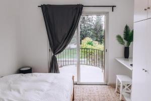 a bedroom with a bed and a sliding glass door at Royal Townhouse in Center Paphos in Paphos City