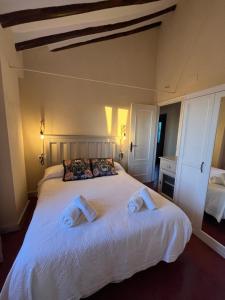 um quarto com uma grande cama branca com toalhas em Cortijo Domínguez - Rural Experience em Lucena