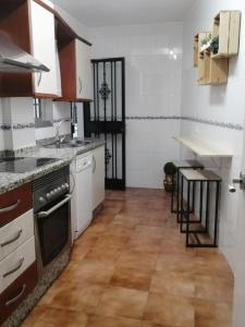 eine Küche mit weißen Schränken und Holzböden in der Unterkunft El rincón de Jesús y Loli in Córdoba