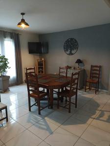 a dining room with a wooden table and chairs at Maison de village in Saint-Loup
