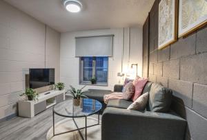 a living room with a couch and a glass table at #10 Phoenix Court By DerBnB, Industrial Chic 1 Bedroom Apartment, Wi-Fi, Netflix & Within Walking Distance Of The City Centre in Sheffield