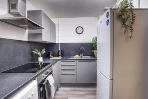eine Küche mit weißen Geräten und einem Kühlschrank in der Unterkunft #10 Phoenix Court By DerBnB, Industrial Chic 1 Bedroom Apartment, Wi-Fi, Netflix & Within Walking Distance Of The City Centre in Sheffield