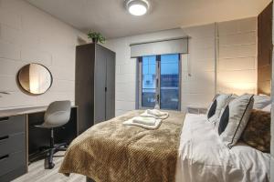 a bedroom with a bed with a desk and a window at #10 Phoenix Court By DerBnB, Industrial Chic 1 Bedroom Apartment, Wi-Fi, Netflix & Within Walking Distance Of The City Centre in Sheffield