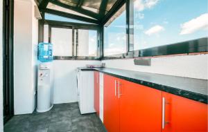 a kitchen with orange cabinets and a washer and dryer at Nice Home In Valldemar With Wifi in Gornal