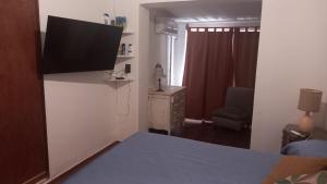 1 dormitorio con TV de pantalla plana en la pared en CASA AMPLIA Y CONFORTABLE en Córdoba