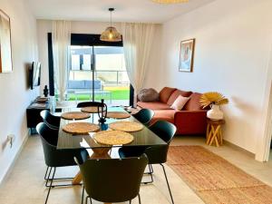 sala de estar con mesa, sillas y sofá en 5 Apartamento Iconic Beach, en Gran Alacant
