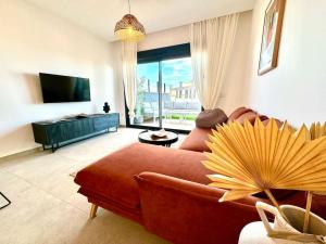 sala de estar con sofá rojo y TV en 5 Apartamento Iconic Beach, en Gran Alacant