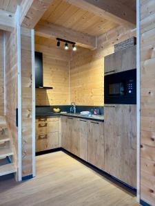 a kitchen with wooden walls and wooden counters at Clofers Nature Chalets Obermöschach in Hermagor
