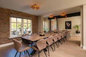 uma grande sala de jantar com uma mesa longa e cadeiras em 't Borghuis em Losser