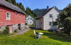 a group of buildings with chairs and a table in a yard at 5 Bedroom Cozy Home In Strandebarm in Strandebarm