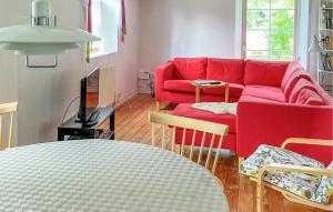 a living room with a red couch and a table at Gorgeous Home In Fjlkinge With House A Panoramic View in Fjälkinge