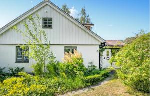 a white house with a garden in front of it at Gorgeous Home In Fjlkinge With House A Panoramic View in Fjälkinge