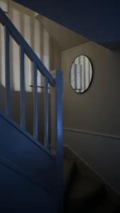 a stairway with a round mirror on a wall at Cozy 3 bedroom House in Great Billing