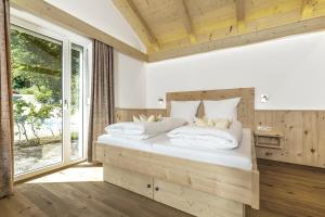 Wellness-Appartements Berchtesgadener Land في أينرينغ: غرفة نوم بسريرين ونافذة كبيرة