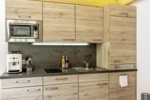 a kitchen with a sink and a microwave at Wellness-Appartements Berchtesgadener Land in Ainring