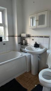 a white bathroom with a sink and a toilet at Cozy 3 bedroom House in Great Billing