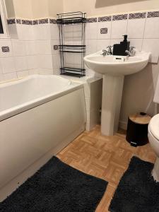 a bathroom with a sink and a bath tub and a toilet at Cozy 3 bedroom House in Great Billing