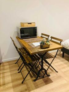 einen Holztisch mit einem Laptop und einer Mikrowelle in der Unterkunft Gite de la Chapelle option SPA in Verchocq