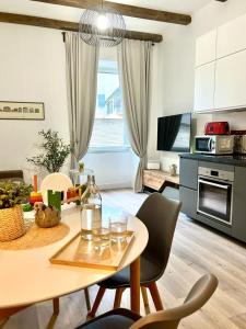 ein Wohnzimmer mit einem Tisch und Stühlen sowie eine Küche in der Unterkunft Happy Family Apartments Vigne in Genua