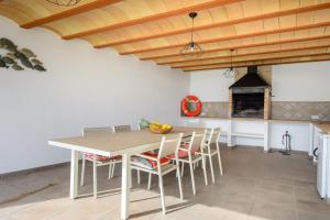 een keuken met een tafel en stoelen en een open haard bij New! Villa Can Blai in Santa Eularia des Riu