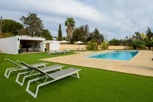 a yard with lounge chairs and a swimming pool at New! Villa Can Pere Blai in Santa Eularia des Riu