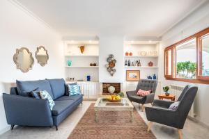 a living room with a blue couch and two chairs at New! Villa Can Blai in Santa Eularia des Riu