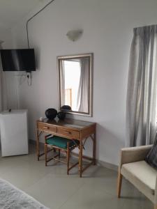 una scrivania in una camera con finestra e divano di Indaba Manor Guesthouse a Port Edward