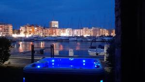 a blue tub sitting on a balcony overlooking a marina at night at Cap Saint Martin Marina in Cap d'Agde