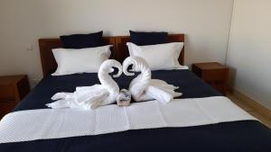 zwei weiße Schwäne auf einem Bett in der Unterkunft Cap Saint Martin Marina in Cap d'Agde