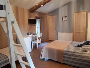 a bedroom with a bed and a desk and a ladder at Domaine de Cozance chambres d'hôtes et gîte in Anjou